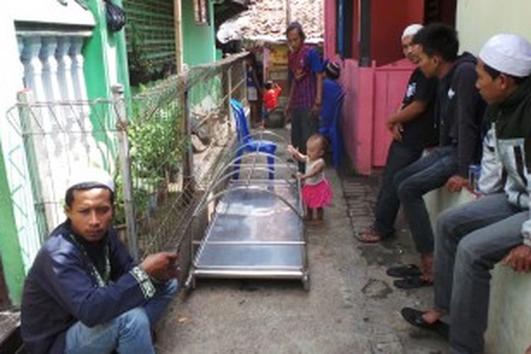 Kerabat tengah menanti di dekat kediaman Abdul Hakim, Tukang ojek yang tewas dengan cara gantung diri. Senin (1/7/2013).