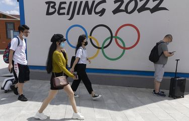 Pengunjung Chongli, salah satu tempat Olimpiade Musim Dingin Beijing 2022, melewati logo Olimpiade di Chongli di Provinsi Hebei, China utara pada 13 Agustus 2020.