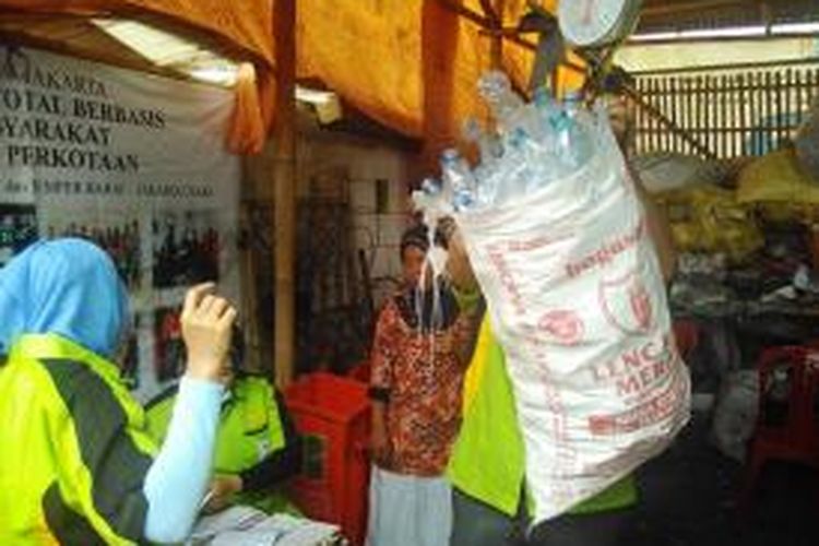 Anggota Bank Sampah Kenanga Peduli Lingkungan di Kelurahan Samper Barat, Jakarta Utara menimbang sampah yang dibawa warga, Selasa (24/11/2015).