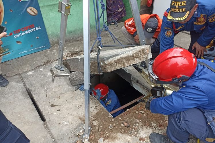 Petugas damkar dari Sektor 2 Palmerah, mengevakuasi sebuah kunci motor milik warga yang tercemplung ke dalam selokan berlapis u-ditch beton di Jalan Palmerah Barat, Palmerah, Jakarta Barat, pada Senin (17/10/2022). 