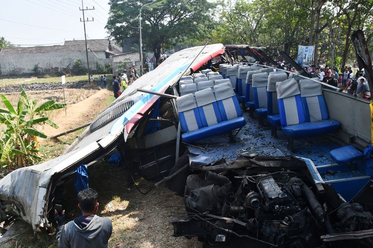 Sejumlah orang mengamati kondisi bus yang rusak akibat bertabrakan di Geneng, Ngawi, Jawa Timur, Kamis (31/8/2023). Menurut data rilis Polres Ngawi pada Kamis (31/8) pukul 12.00 WIB, kecelakaan bus Eka jurusan Yogyakarta-Surabaya yang bertabrakan dengan bus Sugeng Rahayu jurusan Surabaya-Yogyakarta karena kedua sopir menghindari penyeberang jalan itu mengakibatkan tiga orang tewas (2 sopir dan warga penyeberang jalan), serta 17 penumpang dari kedua bus mengalami luka. 