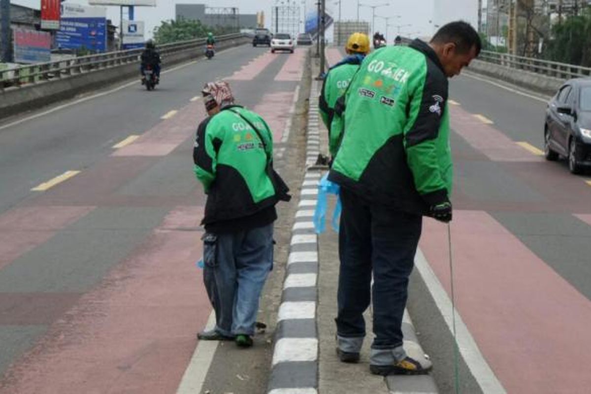 Relawan Go-Jek lakukan aksi sosial #GerakanBersihRanjauPaku di Flyover Roxy, Jakarta, Minggu (10/7/2016).