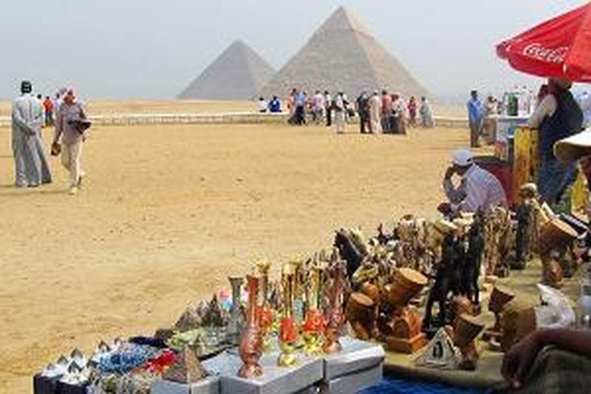 Para penjual suvenir termangu menunggu pembeli di kompleks Piramida Besar Giza di Giza, Mesir, Selasa (21/10/2014). Piramida Besar Giza yang berusia hampir 5.000 tahun masih menjadi ikon pariwisata Mesir paling terkenal di seluruh dunia. 