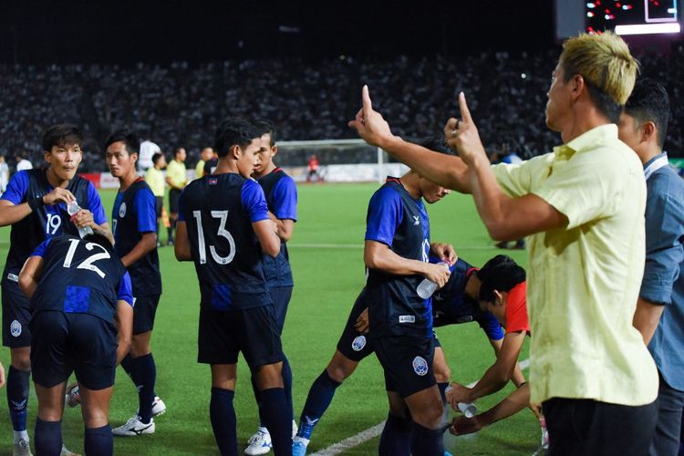 Manajer tim nasional sepak bola Kamboja Keisuke Honda (kanan) berbicara kepada para pemain timnya selama pertandingan sepak bola kualifikasi putaran kedua Piala Dunia 2022 zona Asia antara Kamboja melawan Irak di stadion Olimpiade, Phnom Penh, pada 15 Oktober 2019.