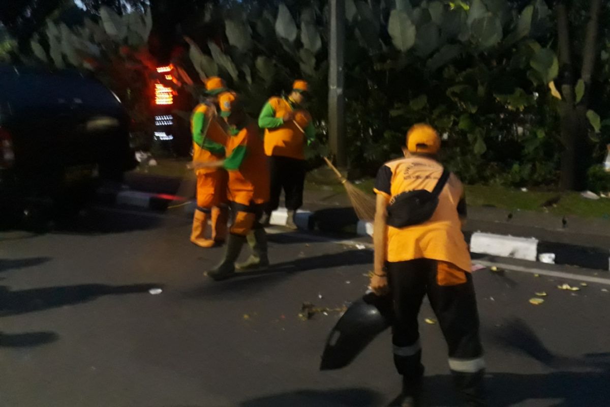 Petugas kebersihan dengan sigap bersihkan sampah di sekitar area panggung Jakarnaval 2018 di Jalan Medan Merdeka Selatan, Jakarta Pusat, Minggu (08/07/2018).