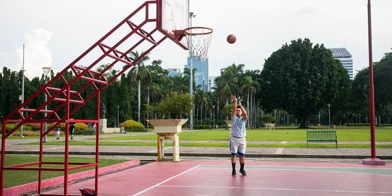 Seorang pengunjung yang datang sore hari ke Monas untuk menikmati fasilitas lapangan basket gratis, Jakarta, Rabu (29/1/2020).