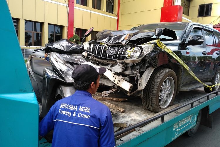 Seseorang melintas di depan mobil Prado milik Jamaludin dan sepeda motor Honda Vario yang dikendarai Reza saat membuang jasad korban ke Kutalimbaru, Deli Serdang.