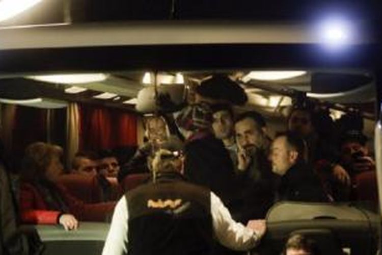 Para imigran mendengar seorang petugas di dalam sebuah bis setelah mereka tiba di kantor Kanselir Jerman di Berlin. 