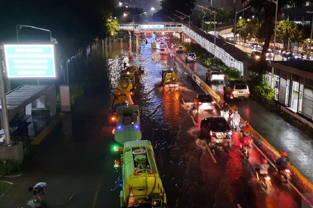 Antrean kendaraan melintas menuju jalur cepat Simpang Susun Semanggi arah Patung Senayan dan Blok M imbas banjir, Sabtu (20/2/2021) malam. 