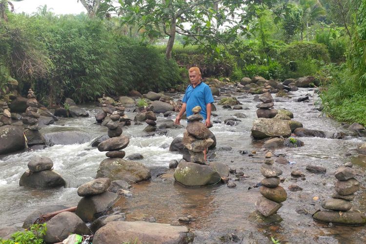 Seorang warga, Apet Suherman (49) menunjukkan puluhan batu bertumpuk di Sungai Cibojong, Desa Jayabakti, Kecamatan Cidahu, Sukabumi, Jawa Barat, Rabu (28/2/2018).