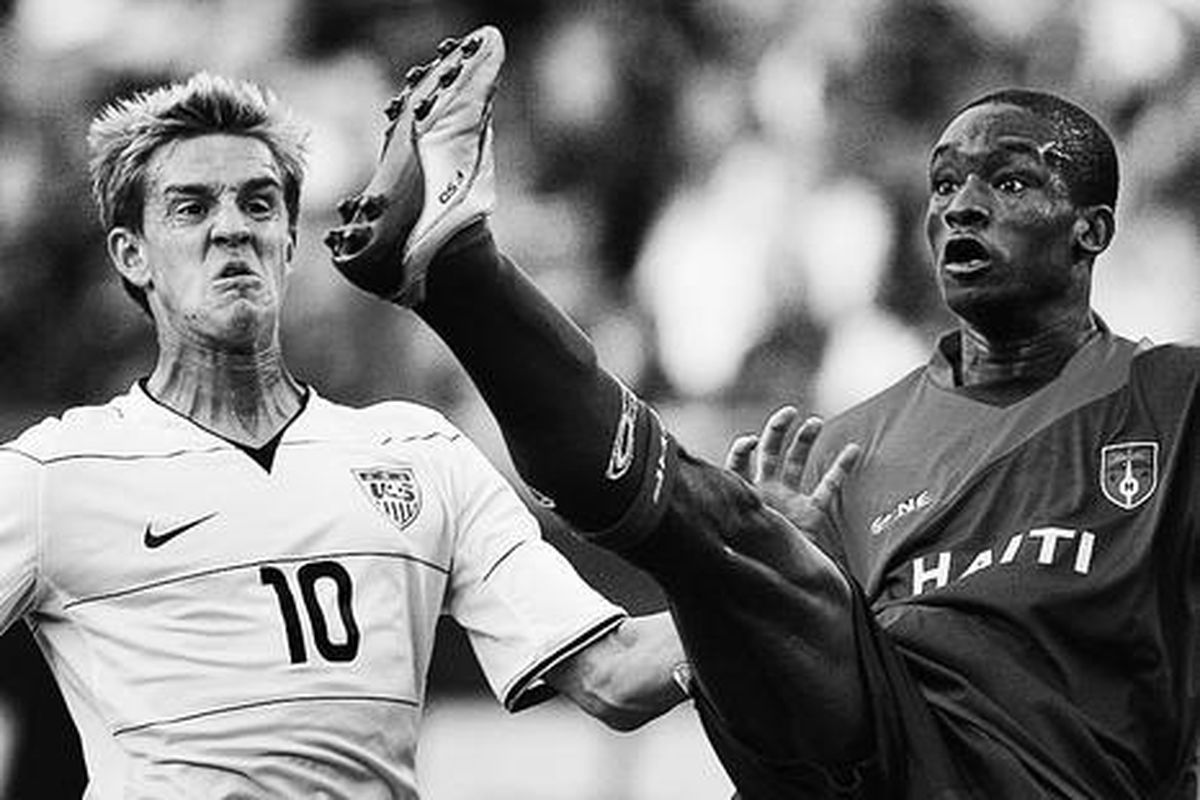 Fabrice Noel (kanan) mengamankan pertahanan Haiti dari pemain AS, Stuart Holden, dalam pertandingan Piala Emas di Stadion Gillette, Foxborough, Amerika Serikat, Sabtu (11/7).