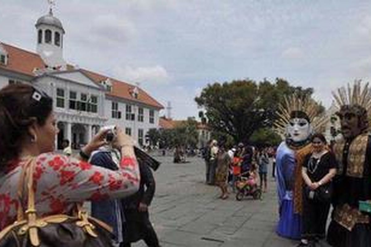 Kelompok kesenian ondel-ondel "Bintang Saroja" asal Rawamangun tampil menghibur wisatawan sekaligus mengamen di kawasan wisata kota tua di depan Museum Fatahillah, Jakarta, Minggu (27/3/2011).  