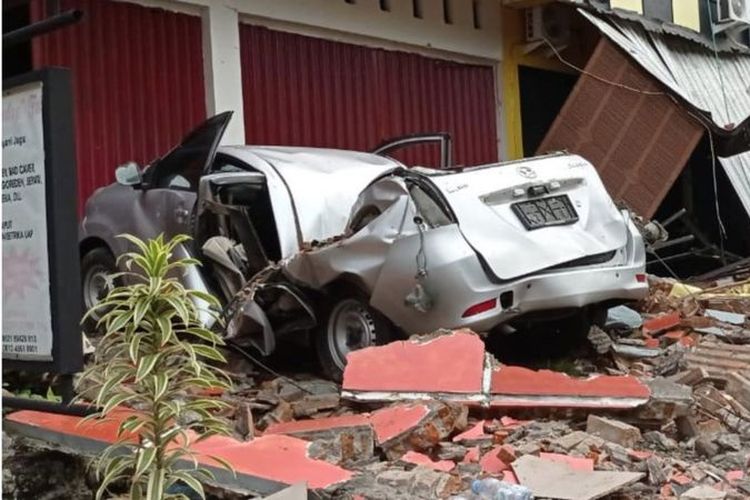 Sebuah mobil dan bangunan rusak akibat gempa bumi, di Mamuju, Sulawesi Barat, Jumat (15/1/2021).