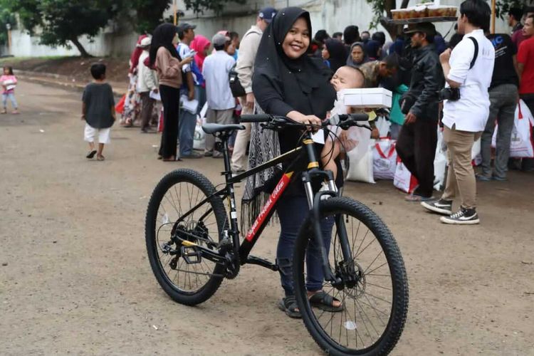 Uswatun Hasanah, warga Kota Serang Banten mendapatkan hadiah sepedah langsung dari Presiden Jokowi usai hafal pancasila di acara penyaluran bantuan beras di Gudang Bulog Serang. Senin (8/1/2024).