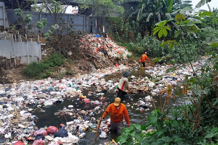 Sejumlah petugas kebersihan berjibaku mendorong sampah dalam operasi pengangkutan sampah Kali Jambe, Kabupaten Bekasi, Jumat (6/9/2019).