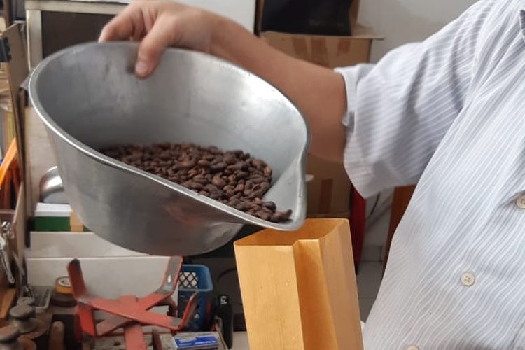 Yulin, pemilik toko kopi Luwak Gondangdia, tengah menuang biji kopi ke dalam kemasan.