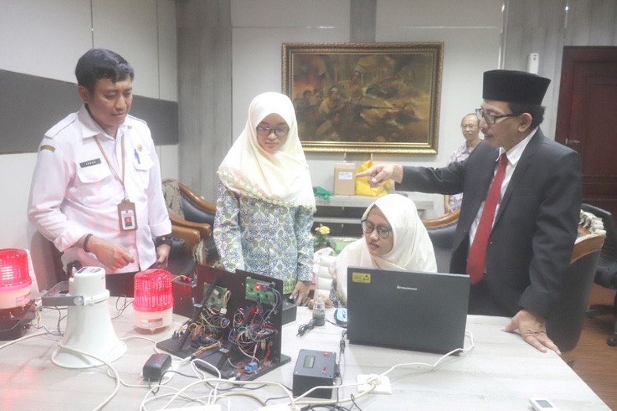 Wakil Ketua Dewan Perwakilan Rakyat Daerah (DPRD) Kota Surabaya AH Thony (kanan) saat melihat alat Integrated Warning System yang diciptakan dua siswi Sekolah Menengah Pertama Negeri (SMPN) 52 Surabaya, yakni Adita Zahra Putri Purwana dan Vanesa Dewi Saraswati. 