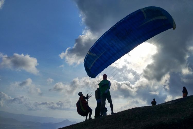 Salah satu peserta festifal paralayang hendak terbang dari puncak Bukit Tunggangan, Kecamatan Durenan Trenggalek, Jawa Timur, Minggu (1/7/2018).