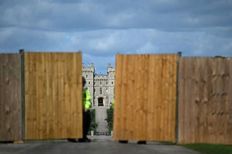 Petugas polisi menutup gerbang di pagar pembatas sementara yang didirikan di Long Walk, menuju Kastil Windsor di Windsor, pada 16 September 2025, pada malam Kunjungan Kenegaraan Presiden AS dan Ibu Negara. Ribuan polisi, barikade baja, hingga larangan drone disiapkan Inggris untuk mengamankan kunjungan Trump ke Kastel Windsor.