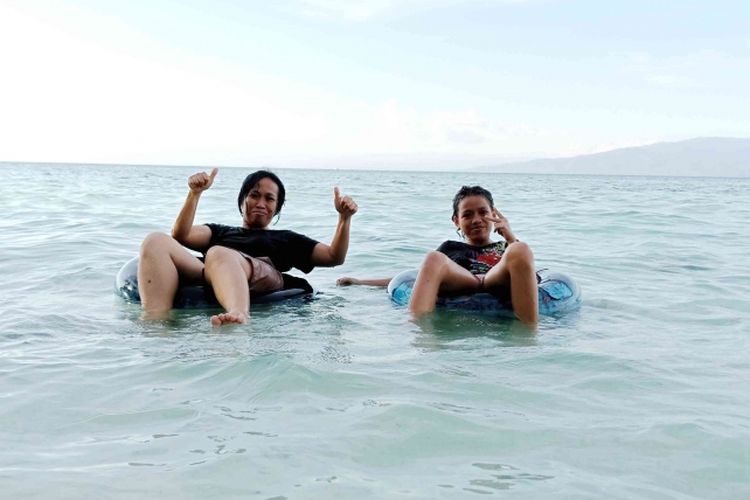Pengunjung menikmati berenang di Pantai Liang