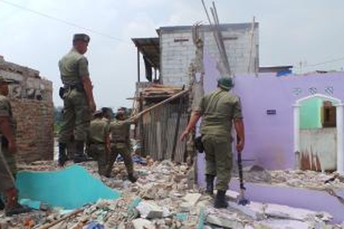 Petugas Satpol PP Bongkar bangunan warga Ria Rio yang telah pindah di rusun Pinus Elok, Cakung, Jakarta Timur. Sabtu (26/10/2013).