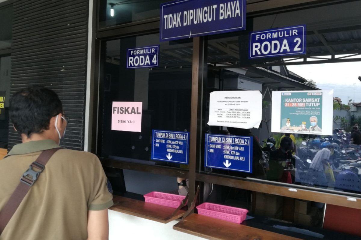 seorang wajib pajak menunggu berkas di depan loket fiskal di kantor Samsat Kota Solo