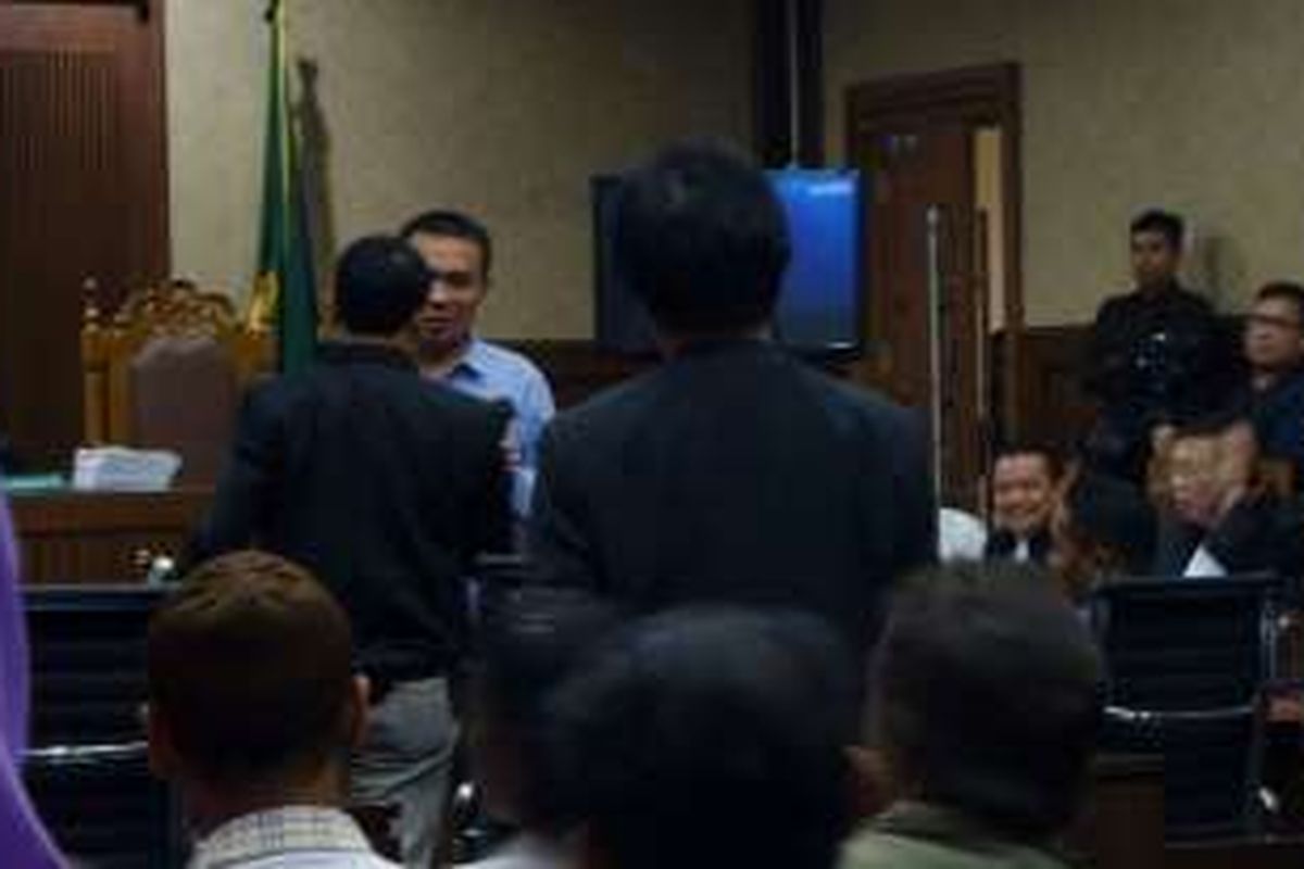 Roy Suryo (tengah, menghadap ke depan) berdiri melihat ke arah dua ahli digital forensik yang sedang bersalaman, Muhammad Nuh dan Rismon Hasiholan Sianipar, dalam sidang kasus pembunuhan Wayan Mirna Salihin di Pengadilan Negeri Jakarta Pusat, Kamis (15/9/2016).