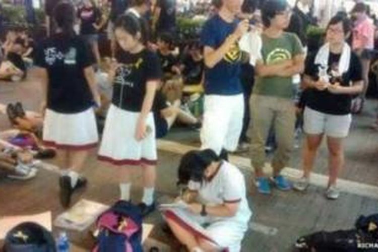 Para pelajar Hongkong rela mengerjakan pekerjaan rumah mereka sambil terus berunjuk rasa.