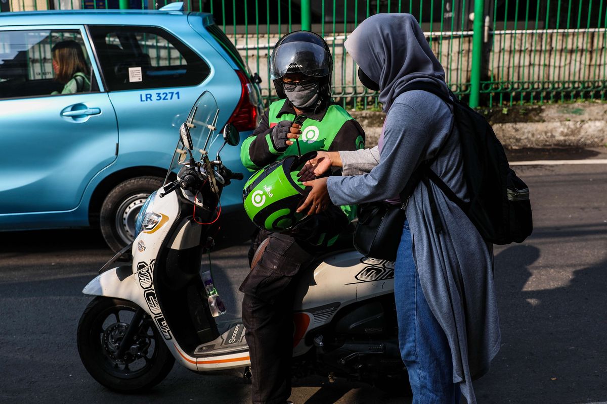 Pengemudi ojek online dengan penumpangnya melintas di Kawasan Stasiun Sudirman, Jakarta Pusat, Senin (8/6/2020). Pemerintah Provinsi DKI Jakarta mengizinkan pengemudi ojek online beroperasi untuk mengangkut penumpang selama PSBB transisi dengan menerapkan protokol kesehatan.