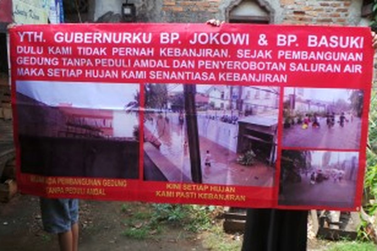 Warga menunjukan poster dampak pembuangan air berbau tak sedap dari PT Indoguna