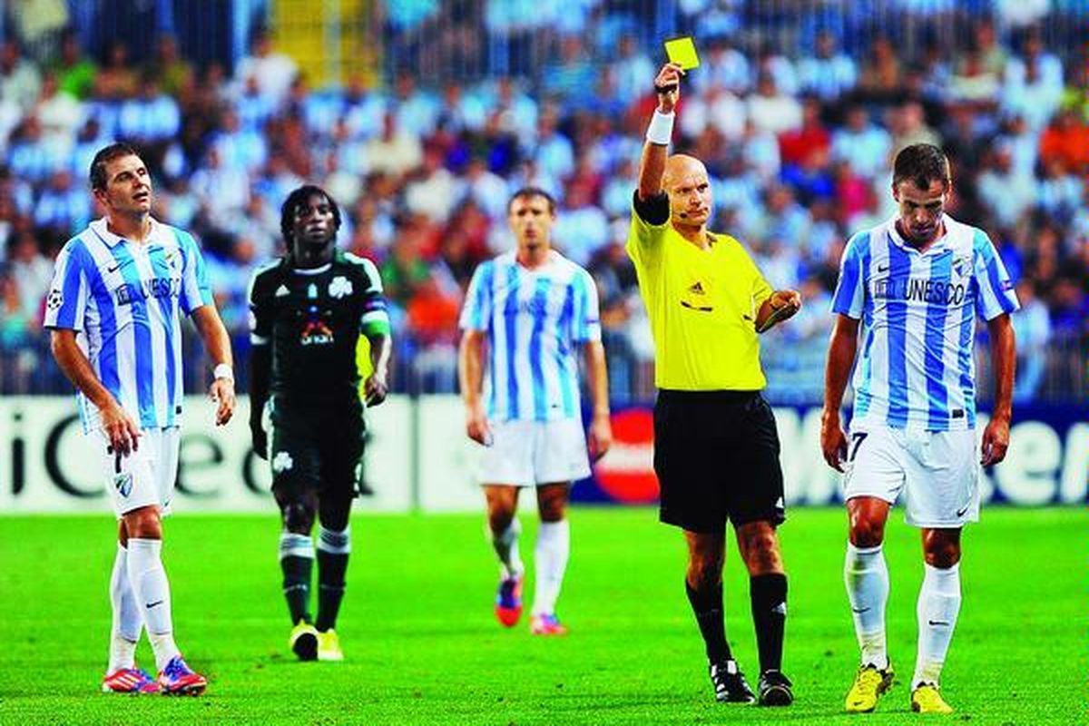 Gelandang Malaga, Duda (kanan), diganjar kartu kuning oleh wasit. Klub Spanyol ini menghadapi klub Yunani, Panathinaikos, dalam play off pertama Liga Champions di markas Malaga, Rabu (22/8). Tuan rumah menang 2-0.
