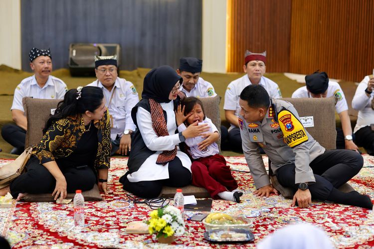 Bupati Banyuwangi Ipuk Fiestiandani saat menenangkan siswa sekolah rakyat yang menangis. 