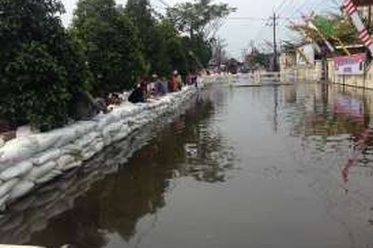 Aliran air rob di menggenangi Kali Sringin dibendung menggunakan tanggul sementara di depan Mapolsek Genuk, Semarang.
