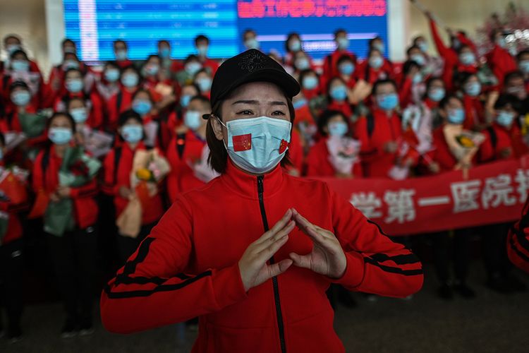 Rombongan petugas medis dari Provinsi Jilin dalam acara perpisahan setelah menyelesaikan masa tugasnya membantu menangani pasien virus corona, di Bandara Tianhe yang baru dibuka kembali di Wuhan, Hubei, China, Rabu (8/4/2020). Ribuan orang bergegas meninggalkan Wuhan setelah otoritas mencabut kebijakan lockdown selama lebih dari dua bulan di lokasi yang diketahui sebagai episenter awal virus corona tersebut.