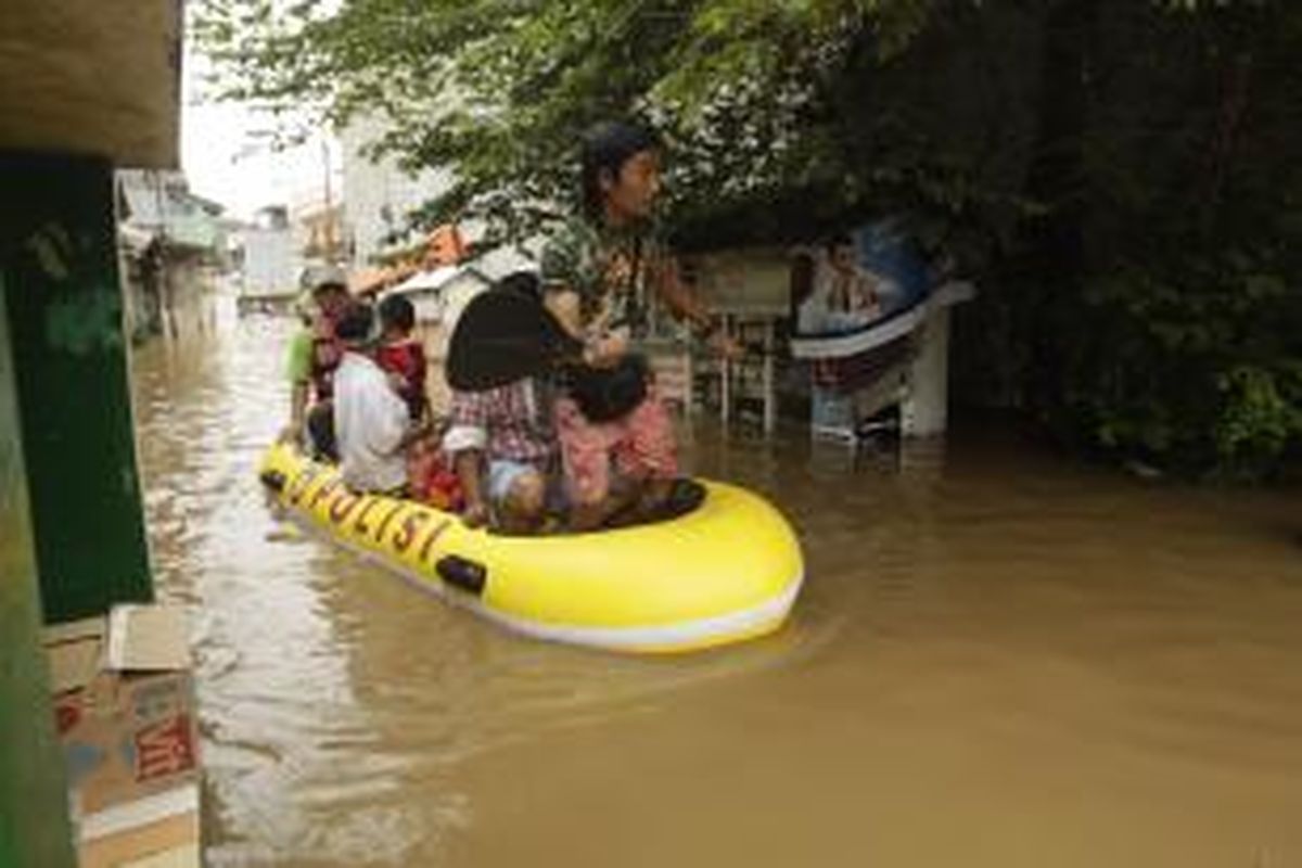 Warga diungsikan menggunakan perahu karet dari banjir yang melanda kawasan Bidara Cina, Jakarta, Senin (13/1/2014). Hujan yang melanda Jakarta sejak Minggu pagi ditambah meluapnya sungai Ciliwung akibat banjir kiriman dari Bogor mengakibatkan sejumlah kawasan ini terendam banjir sejak Minggu malam. KOMPAS IMAGES/RODERICK ADRIAN MOZES