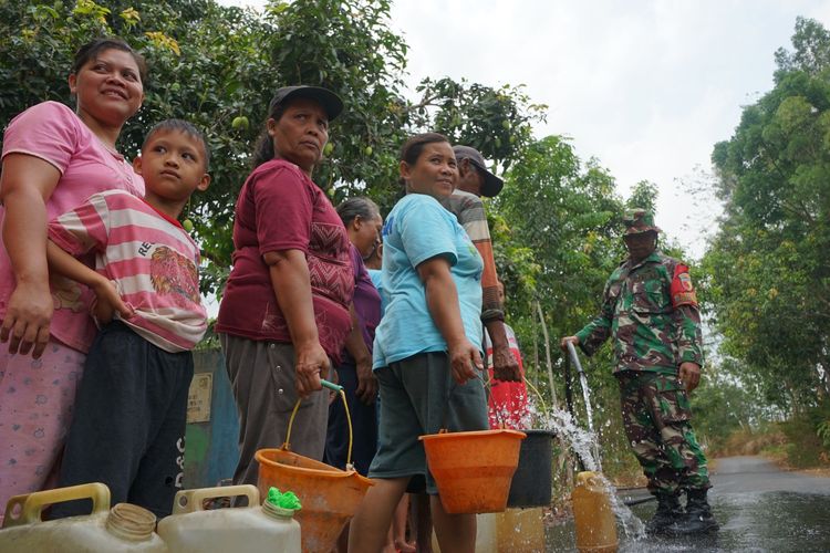 Warga Desa Suru, Kecamatan Ngetos, Kabupaten Nganjuk Jawa Timur, saat mengantre air yang mengalir deras dari pipa yang dipasang TNI belum lama ini.