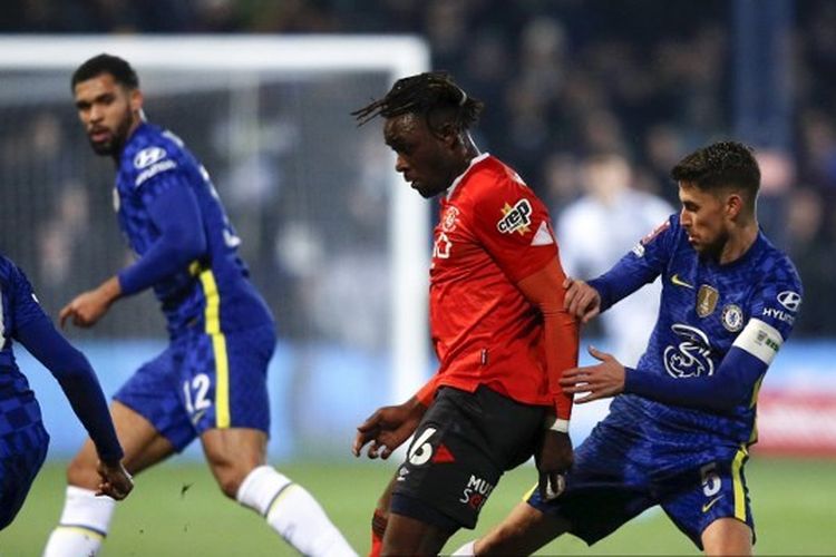 Admiral Muskwe (tengah) dibayangi oleh Jorginho dalam laga Piala FA Luton Town vs Chelsea yang digelar di Stadion Kenilworth Road, Luton, pada Rabu (2/3/2022) malam waktu setempat. (Foto: AFP/Adrian Dennis)