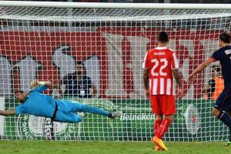 Penjaga gawang Olympiakos, Roberto, menggagalkan tendangan penalti striker Paris Saint-Germain, Zlatan Ibrahimovic (kanan), pada matchday pertama Grup C Liga Champions, Selasa (17/9/2013). PSG menang 4-1.