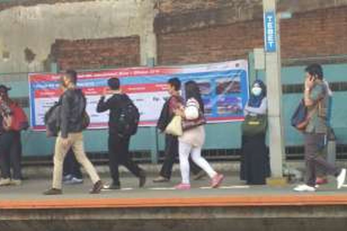 Para pengguna kereta rel listrik (KRL) tampak membaca spanduk pengumuman kenaikan tarif KRL yang dipasang di pagar peron Stasiun Tebet, Jakarta Selatan, Jumat (19/8/2016). Kenaikan tarif Rp 1.000 akan diberlakukan mulai 1 Oktober 2016.