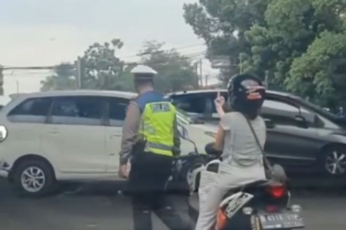 Seorang pemotor mengacungkan jari tengah ke polisi lalu lintas (polantas) di kolong flyover Pasar Rebo, Jakarta Timur, Senin (17/1/2022).