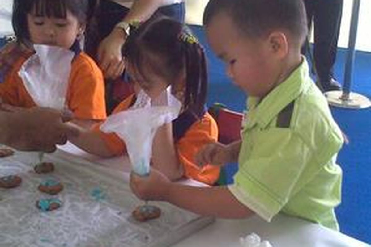 Evander (3, baju hijau), murid Sekolah Bhakti Utama, Kerendang Selatan, Jakarta Barat, coba menghias kue dalam stan Bogakids dalam Bogasari Expo Jakarta 2009, pada 20 November 2009.