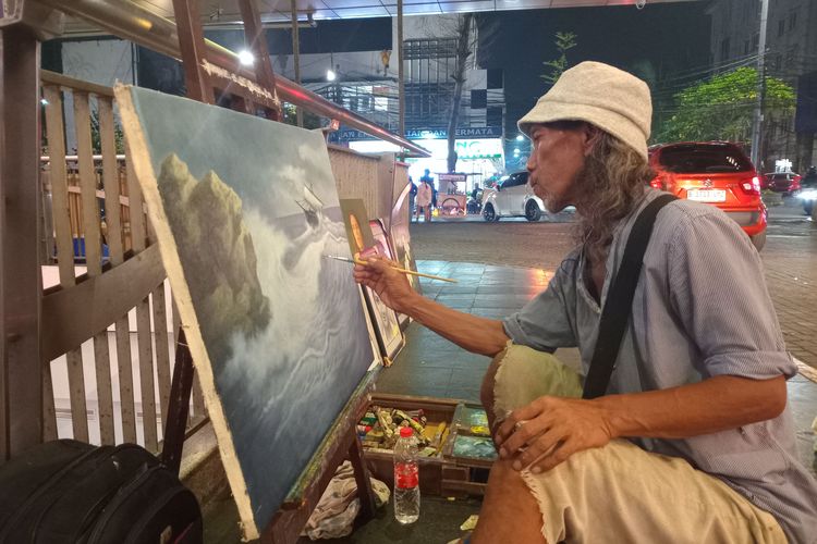 Pelukis jalanan bernama Mulidi atau Atu (51) sedang melukis di depan Blok M Square, Jakarta Selatan, Selasa (18/6/2024).