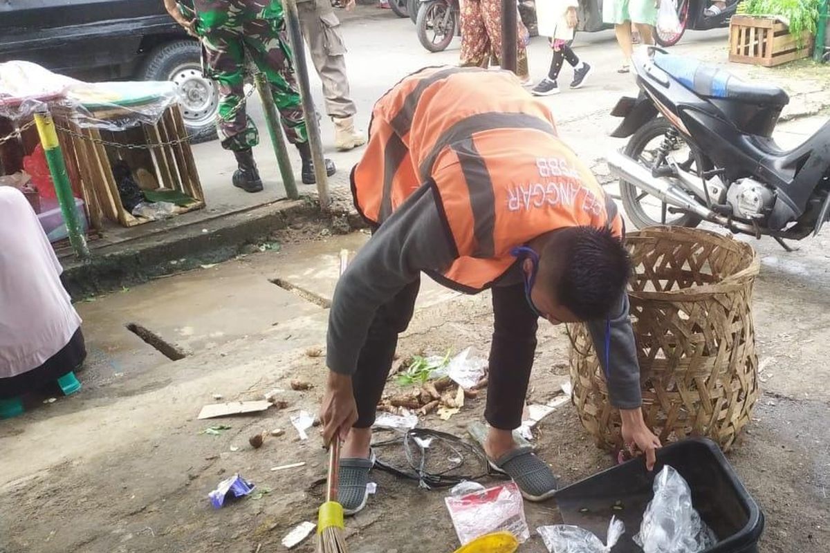 Seorang warga tengah menjalani sanksi sosial karena melanggar protokol kesehatan, tidak mengenakan masker dalam operasi Tibmas yang digelar Satpol PP Kecamatan Tanjung Priok, Jakarta Utara, Jumat (4/3/2022).