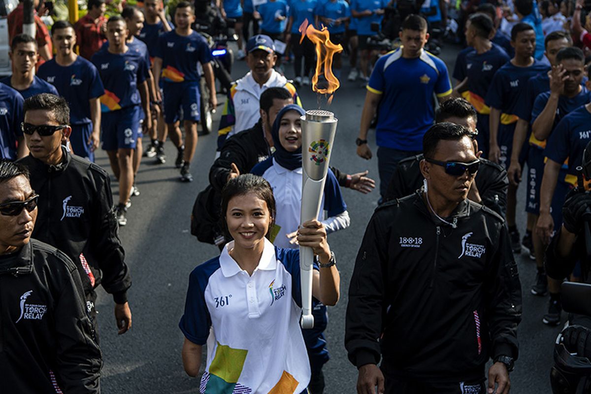 Atlet lari paragames (difabel) Nanda Mei Sholihah menjadi salah satu pembawa obor saat prosesi pawai obor Asian Games 2018 melintasi kawasan Jalan Brigjen Katamso, Yogyakarta, DI Yogyakarta, Kamis (19/7/2018). Prelude rangkaian kegiatan Asian Games dimulai dengan perhelatan pawai obor (torch relay) dari Yogyakarta sebagai kota pertama dan akan berlangsung di 17 provinsi dan 53 kota lainnya di Tanah Air.