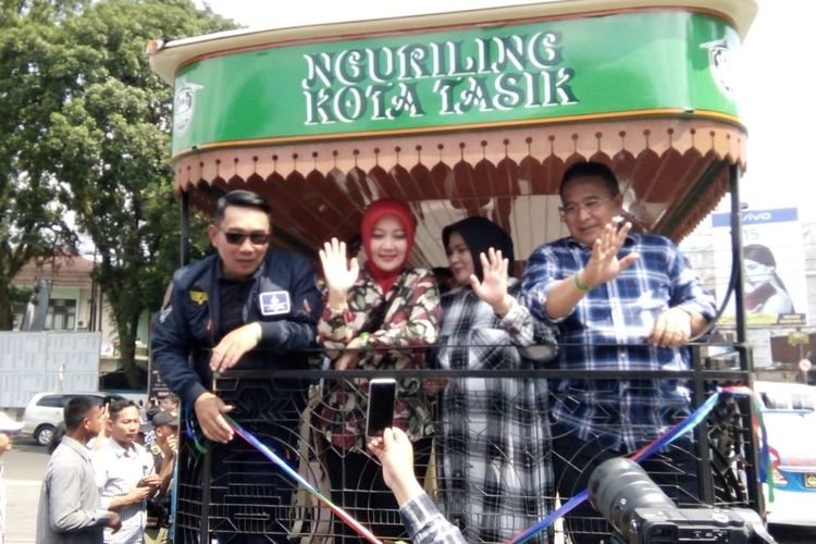 Gubernur Jabar Ridwan Kamil bersama Wali Kota Tasikmalaya Budi Budiman, didampingi istri-istrinya sedang menaiki bus wisata Kota Tasikmalaya (Ngulisik), Minggu (21/4/2019).