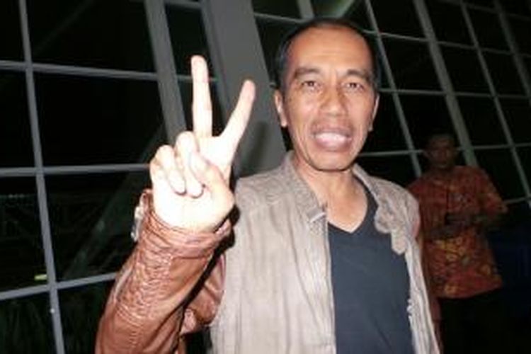Gubernur DKI Jakarta Joko Widodo mengangkat dua jari sebagai tanda damai sebelum menonton konser Slank, Jumat (13/12/2013).