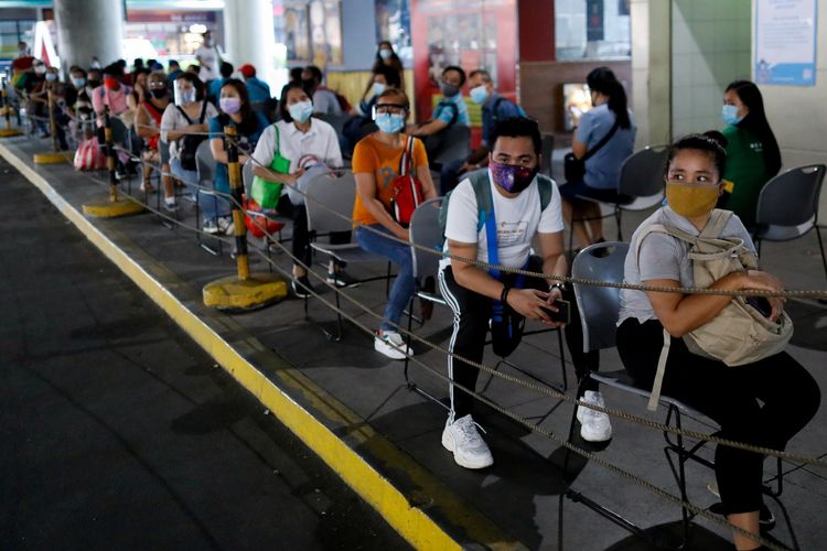 Para calon penumpang memakai masker untuk melindungi diri dari Covid-19, saat menanti kedatangan bus di Quezon City, Metro Manila, Filipina, 14 Juli 2020.
