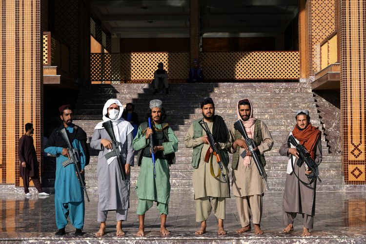 Pejuang Taliban berjaga di sebuah masjid pada hari pertama Idul Fitri di Kabul, Afghanistan, Minggu, 1 Mei 2022. Siapa Taliban dan apa tujuannya? 