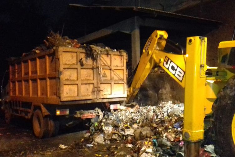 Petugas mengebut pengangkutan sampah di Kampung Sinarmulya, Kelurahan Karawang Wetan, Kecamatan Karawang Timur, Kabupaten Karawang, Kamis (13/12/2018) malam, setelah mendapat protes dari warga dengan memblokade jalan.
