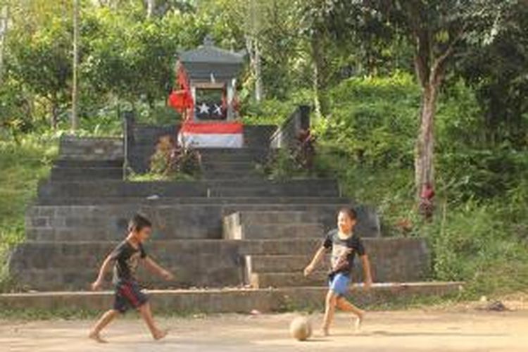 Anak-anak bermain di tanah kosong dekat Monumen Gelar atau Lembah Merdeka di Kabupaten Jembrana, Bali.